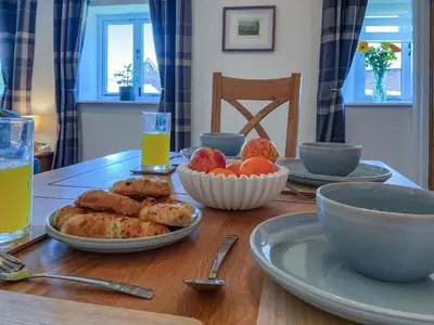 a table with plates of food and bowls of fruit at Abbey Cottage in St Bees