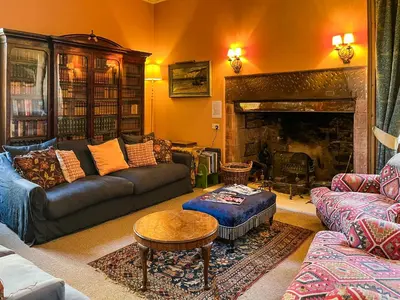 a living room with a couch and a fireplace at Amisfield Tower in Dumfries