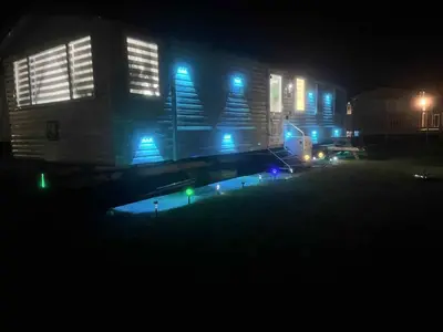 a building lit up at night with blue lights at the heaths caravan hire Craig Tara in Minishant
