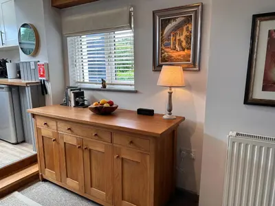 a kitchen with a bowl of fruit on a wooden cabinet at Charming cosy cottage near the Lake District in Penrith