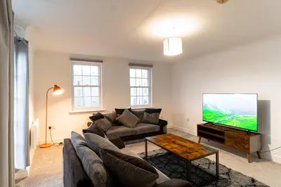a living room with a couch and a flat screen tv at Lovely 2 Bed Harbourside Apartment with Sea Views in Whitehaven