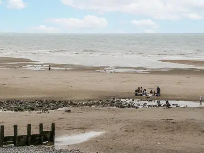 a group of people sitting on the beach at Puffin in St Bees