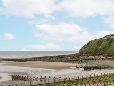 a beach with a fence and the ocean at Sandpiper in St Bees