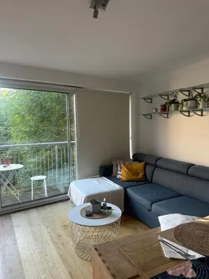 a living room with a blue couch and a large window at Central London in Moffat