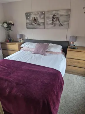 a bedroom with a large bed with a purple blanket at Shep2 Caravans in Ballantrae