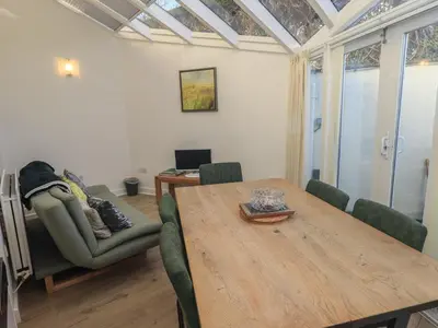 a living room with a wooden table and chairs at Swirl Howe in Keswick