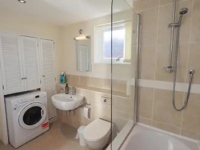 a bathroom with a toilet sink and a washing machine at Swirl Howe in Keswick