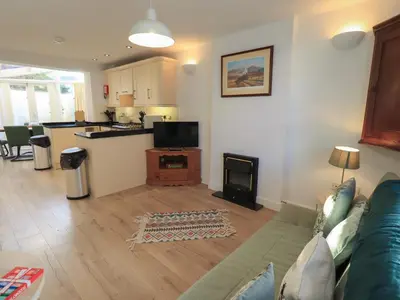 a living room with a blue couch and a kitchen at Swirl Howe in Keswick