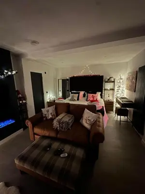 a living room with a couch and a bed at Hamish's Hideaway in Eaglesfield