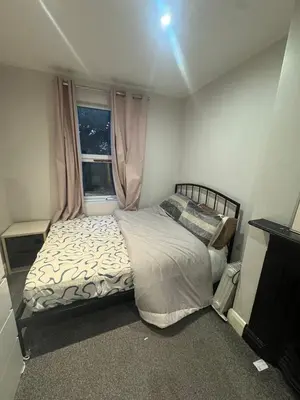 a small bedroom with a bed and a window at Amazing Flat in London in Moffat