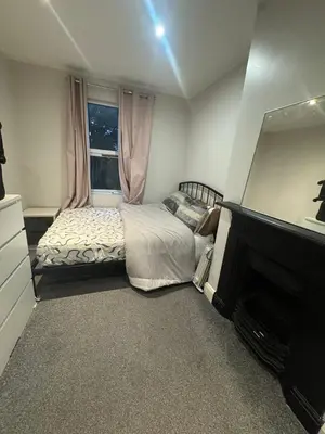 a bedroom with a bed and a fireplace and a window at Amazing Flat in London in Moffat