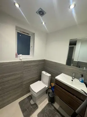 a bathroom with a white toilet and a sink at Amazing Flat in London in Moffat