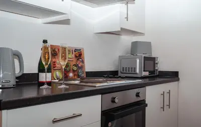 a kitchen with a counter top with a microwave at Bega House Apartment in Whitehaven