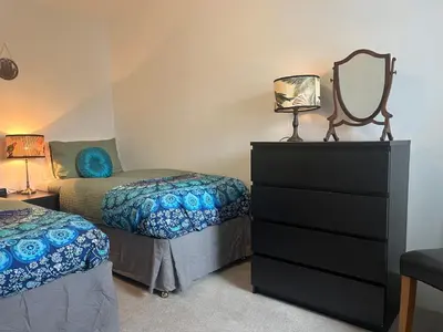 a bedroom with two beds and a dresser with a mirror at Stay Still Indian Court in Dalston