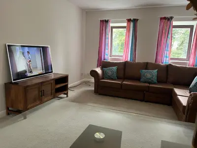 a living room with a couch and a flat screen tv at Stay Still Indian Court in Dalston
