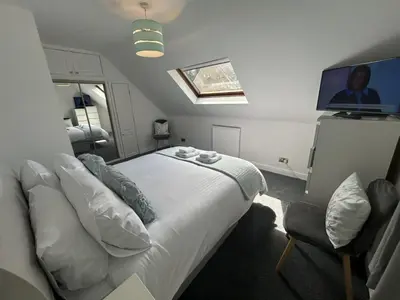 a bedroom with a bed and a flat screen tv at The Stables in Symington in Symington