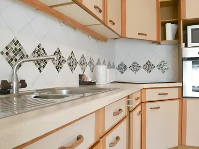 a kitchen with wooden cabinets and a sink at Brigham Farm Apartments in Keswick