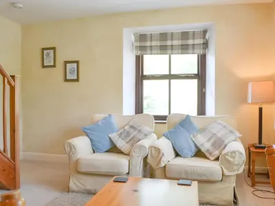 a living room with two chairs and a table at Brigham Farm Apartments in Keswick