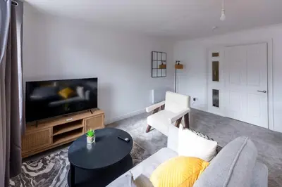 a living room with a couch and a flat screen tv at Bright 1 Bed Harbour-side Apartment with Sea Views in Whitehaven