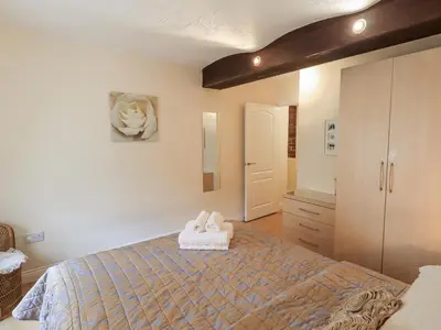 a bedroom with a bed with towels on it at The Coach House in Wigton