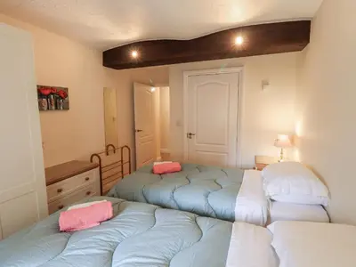 a room with two beds and a desk and a table at The Coach House in Wigton