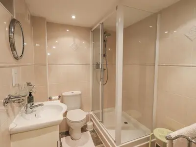 a bathroom with a shower and a toilet and a sink at The Coach House in Wigton