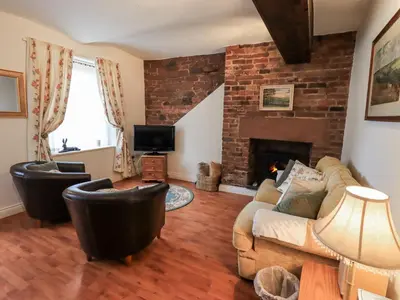 a living room with a couch and a fireplace at The Coach House in Wigton