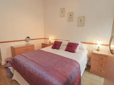 a bedroom with a bed with two night stands and two lamps at The Hayloft in Wigton