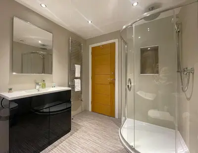 a bathroom with a sink and a glass shower at Fellside Hideaway in Keswick