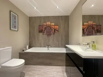 a bathroom with a tub and a toilet and a sink at Fellside Hideaway in Keswick