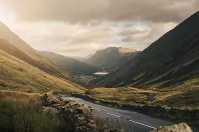 a road in the middle of a valley with mountains at The Hide - Ridgestone in Penrith