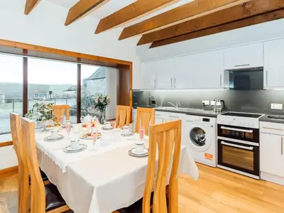 a kitchen with a table with a white table cloth at Middle Byre in Girthon