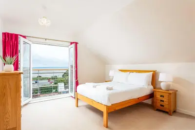 a bedroom with a bed and a large window at The Portland Penthouse - Donnini Apartments in Troon