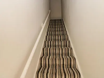 a staircase in a room with a carpet at Cumberland House in Workington