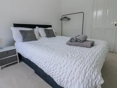 a bedroom with a large bed with towels on it at Cumberland House in Workington
