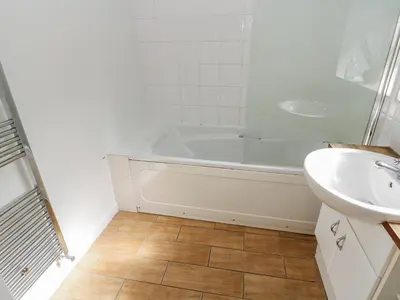 a white bathroom with a tub and a sink at Cumberland House in Workington