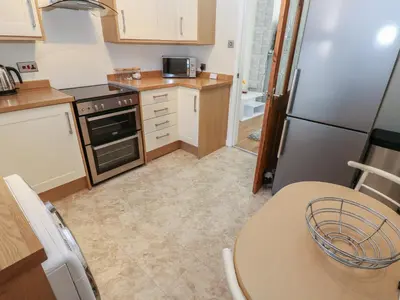 a small kitchen with a table and a refrigerator at Lonsdale Street in Workington