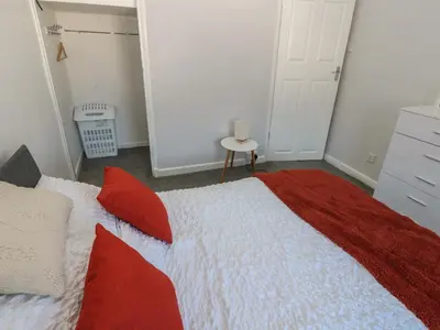 a bedroom with a large bed with red pillows at Lonsdale Street in Workington