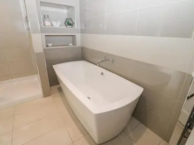 a white bathroom with a tub and a sink at Hampton House in St Bees