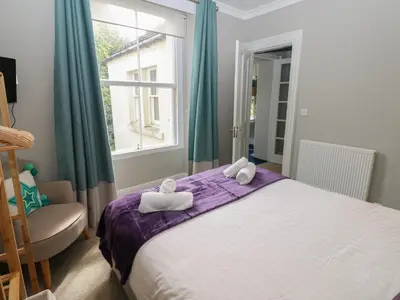 a bedroom with a bed and a chair and a window at Hampton House in St Bees