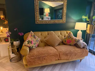 a couch in a living room with a mirror at The Rookery in Moffat