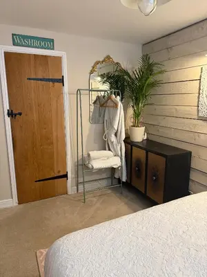 a bedroom with a door and a chair and a mirror at The Rookery in Moffat