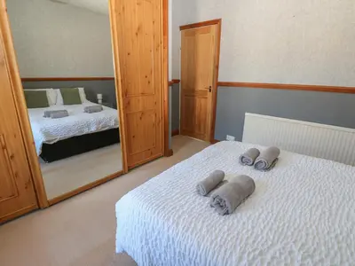 a bedroom with two beds and a large mirror at Bolton Terrace in Workington