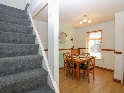 a kitchen and dining room with stairs and a table at Bolton Terrace in Workington