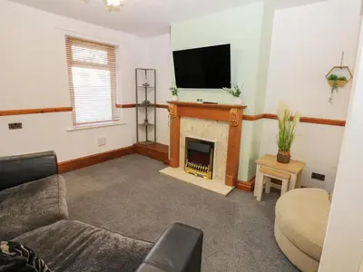 a living room with a fireplace and a flat screen tv at Bolton Terrace in Workington