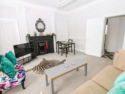 a living room with a couch and a fireplace at Lowther Suite in Whitehaven