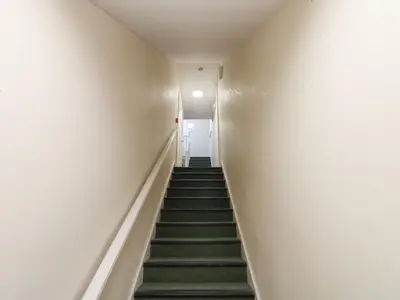 a staircase in a building with green carpeted stairs at Curwen Apartment in Workington