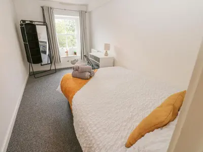 a bedroom with a large bed and a window at Georgian Town House in Whitehaven