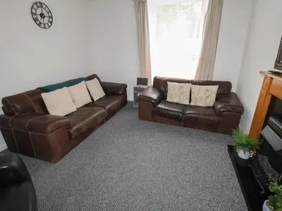 a living room with two leather couches and a window at Georgian Town House in Whitehaven