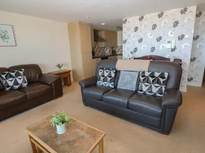 a living room with two leather couches and a table at Pears Suite in Whitehaven